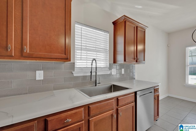 kitchen featuring light tile patterned floors, decorative backsplash, sink, and stainless steel dishwasher