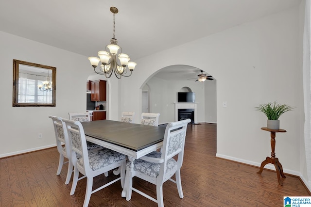 dining room featuring dark wood-type flooring and ceiling fan with notable chandelier