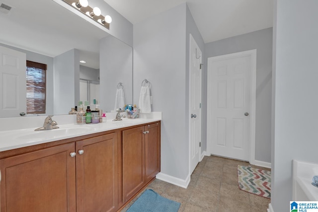 bathroom with vanity, tile patterned floors, and a bath