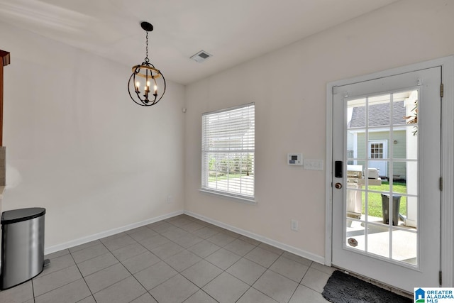 entryway with a notable chandelier and light tile patterned flooring