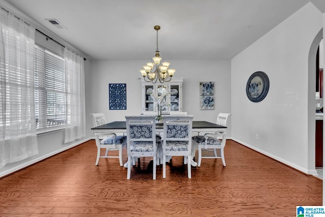 dining room with a notable chandelier and wood-type flooring