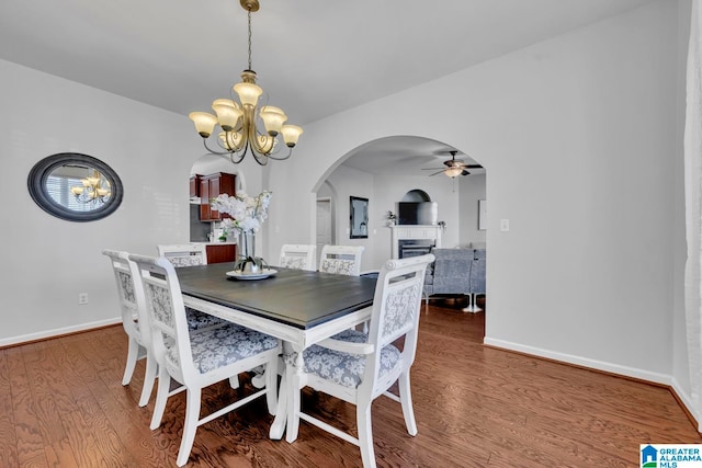 dining area featuring wood-type flooring and ceiling fan with notable chandelier