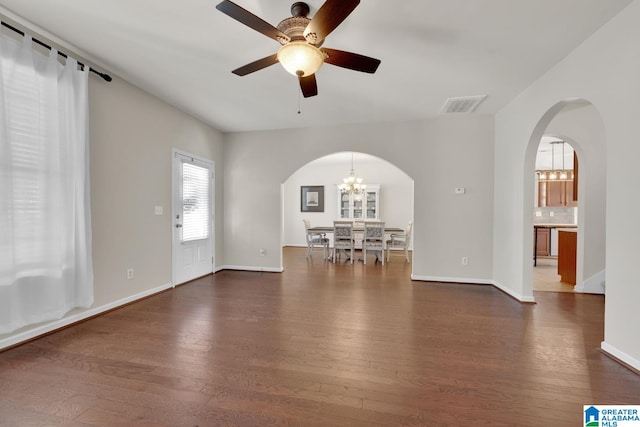 unfurnished living room with dark hardwood / wood-style floors and ceiling fan with notable chandelier