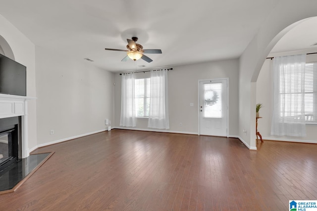 unfurnished living room with ceiling fan and dark hardwood / wood-style flooring