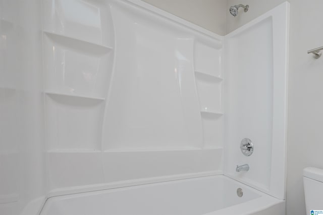 bathroom featuring shower / tub combination and toilet