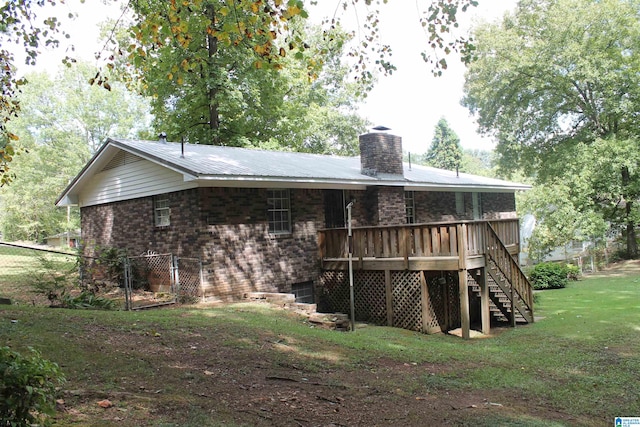 rear view of house featuring a deck and a yard