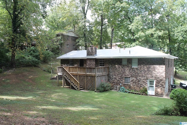 exterior space with a wooden deck, a yard, and central AC