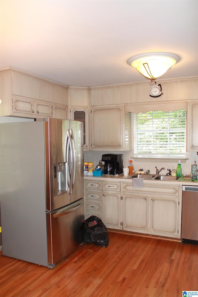 kitchen with light hardwood / wood-style flooring, stainless steel appliances, and sink