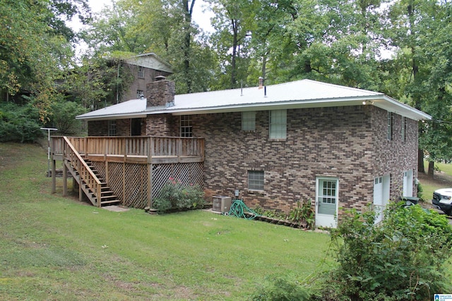 rear view of property featuring a wooden deck, central AC, and a yard