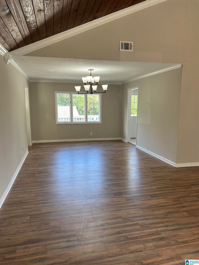 empty room featuring dark hardwood / wood-style flooring, vaulted ceiling, an inviting chandelier, and crown molding