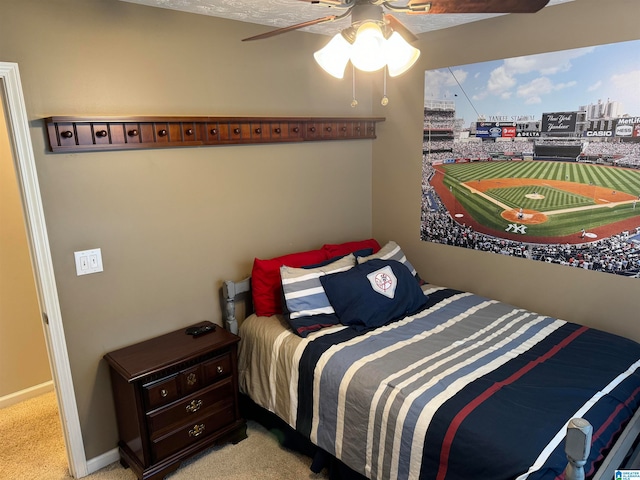 carpeted bedroom with ceiling fan and a textured ceiling