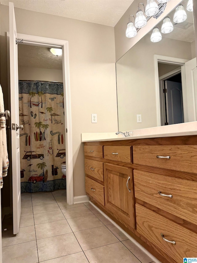 bathroom with curtained shower, vanity, a textured ceiling, toilet, and tile patterned floors