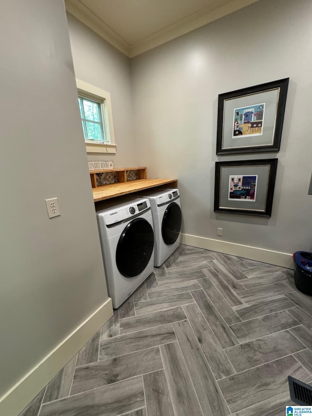 laundry room with crown molding and washing machine and clothes dryer