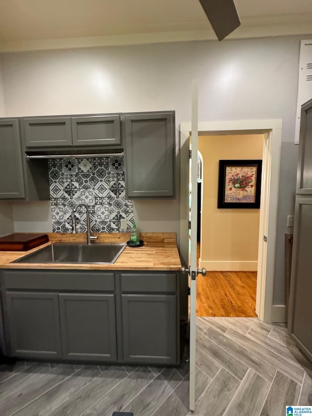 kitchen with gray cabinets, sink, and decorative backsplash