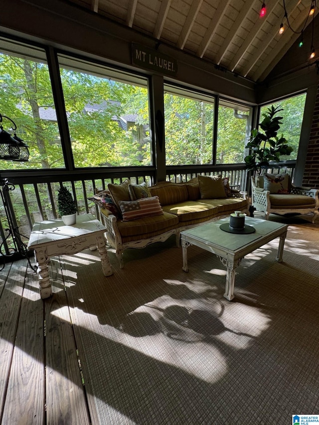 sunroom / solarium with wood ceiling, a healthy amount of sunlight, and lofted ceiling with beams