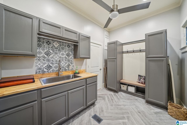 kitchen featuring ornamental molding, gray cabinets, and sink