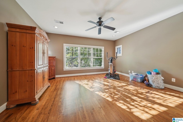 workout area with light hardwood / wood-style floors and ceiling fan