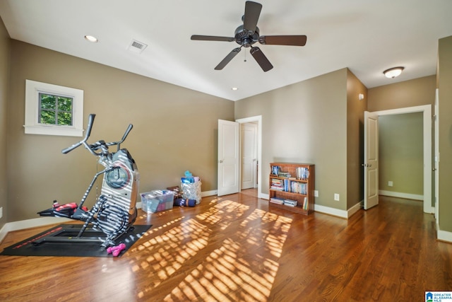 workout area featuring dark wood-type flooring and ceiling fan