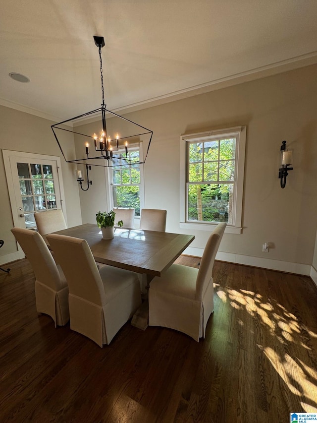 dining area with dark hardwood / wood-style flooring, a notable chandelier, and crown molding