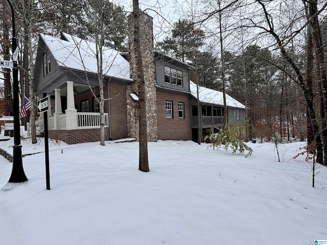 snow covered property featuring covered porch