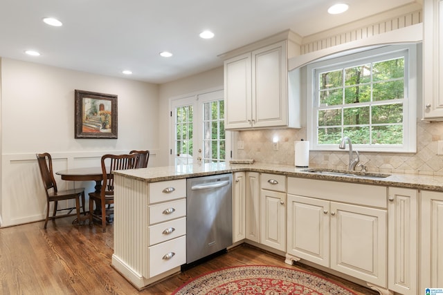 kitchen featuring sink, stainless steel dishwasher, light stone countertops, dark hardwood / wood-style flooring, and decorative backsplash