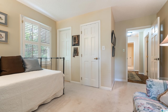 bedroom with a textured ceiling and light carpet