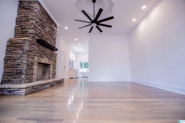 unfurnished living room with baseboards, ceiling fan, wood finished floors, and crown molding