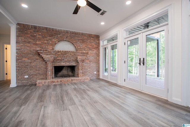 unfurnished living room with visible vents, a wealth of natural light, wood finished floors, and a ceiling fan