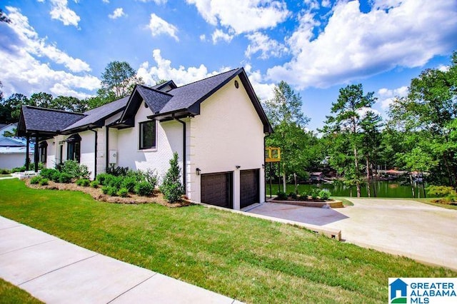 view of property exterior featuring driveway, an attached garage, stucco siding, and a yard