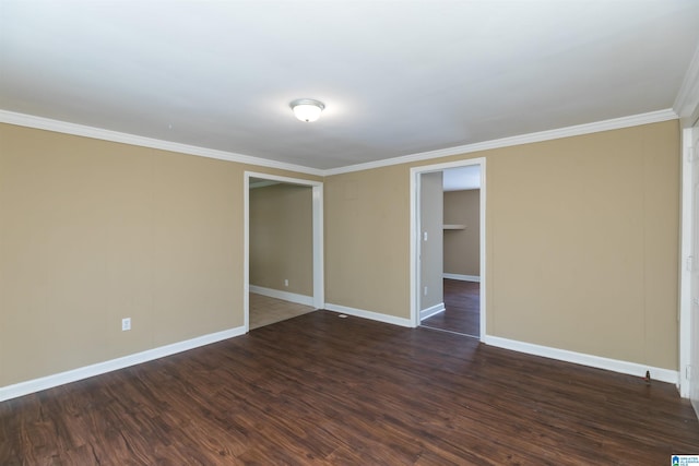 spare room with crown molding and dark wood-type flooring