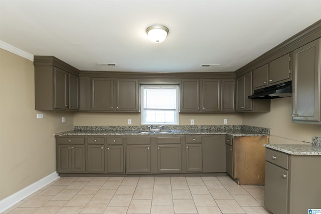 kitchen featuring ornamental molding, dark stone countertops, light tile patterned flooring, and sink