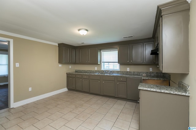 kitchen featuring dark stone countertops, crown molding, and sink