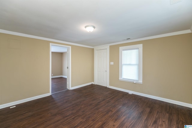 spare room with ornamental molding and dark hardwood / wood-style floors