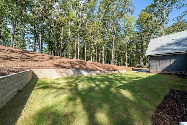 rear view of house featuring board and batten siding and a lawn