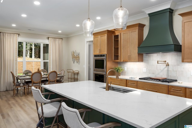 living room featuring ornamental molding, light wood-type flooring, a chandelier, a fireplace, and a tray ceiling