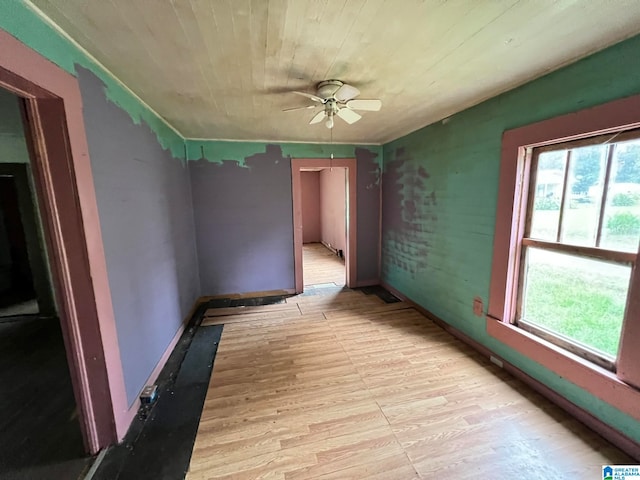 empty room with light hardwood / wood-style flooring, ceiling fan, wooden ceiling, and a healthy amount of sunlight