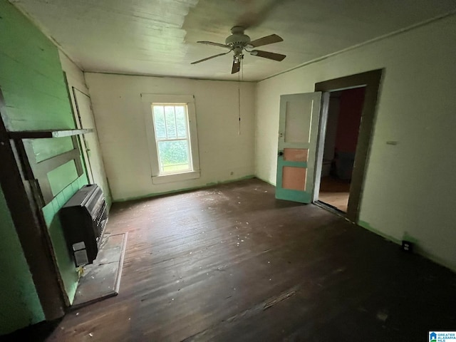 unfurnished living room with heating unit, ceiling fan, and dark hardwood / wood-style flooring