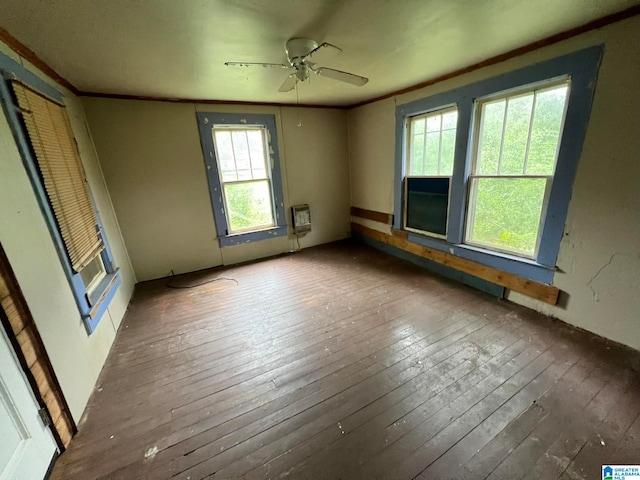 empty room featuring ornamental molding, heating unit, ceiling fan, and dark hardwood / wood-style floors