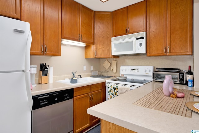 kitchen featuring white appliances and sink