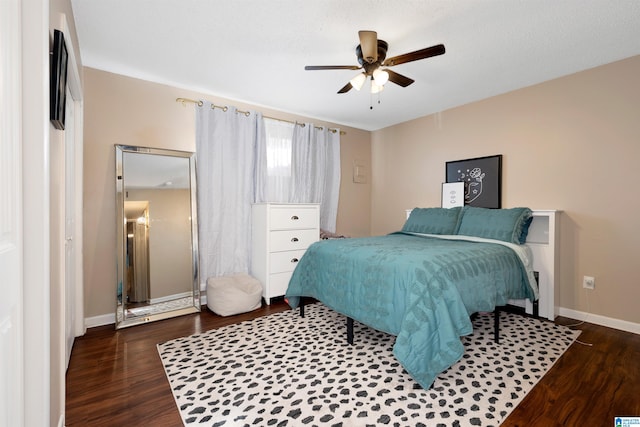 bedroom with dark hardwood / wood-style flooring and ceiling fan