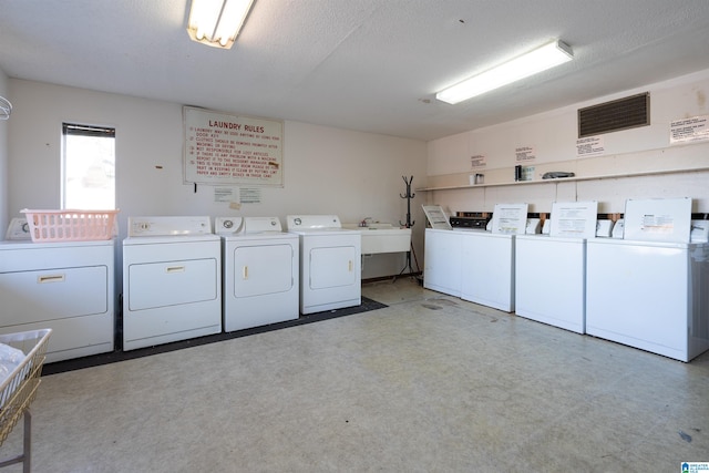 laundry area with a textured ceiling and washer and dryer