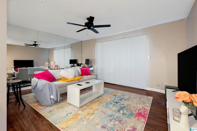 living room with ceiling fan and dark wood-type flooring