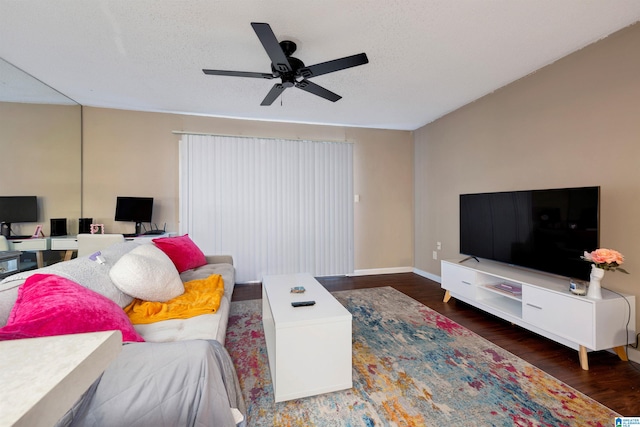 living room featuring ceiling fan, a textured ceiling, and dark hardwood / wood-style floors