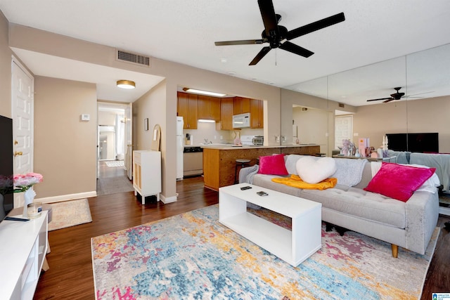 living room with ceiling fan and dark hardwood / wood-style flooring