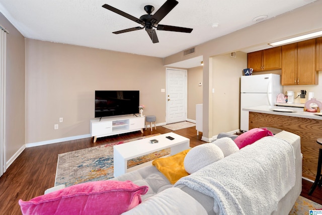 living room featuring ceiling fan, a textured ceiling, and dark hardwood / wood-style flooring