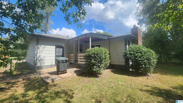 rear view of property featuring a lawn