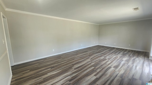 unfurnished room featuring ornamental molding, baseboards, dark wood finished floors, and visible vents