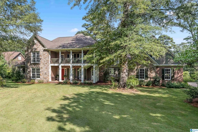 view of front of property featuring a balcony and a front lawn