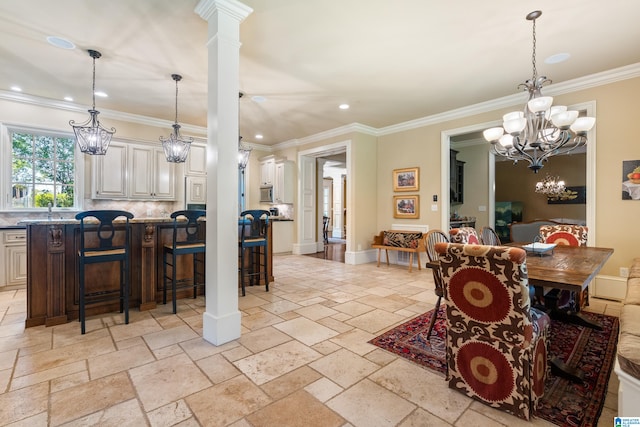 dining space featuring ornamental molding and decorative columns