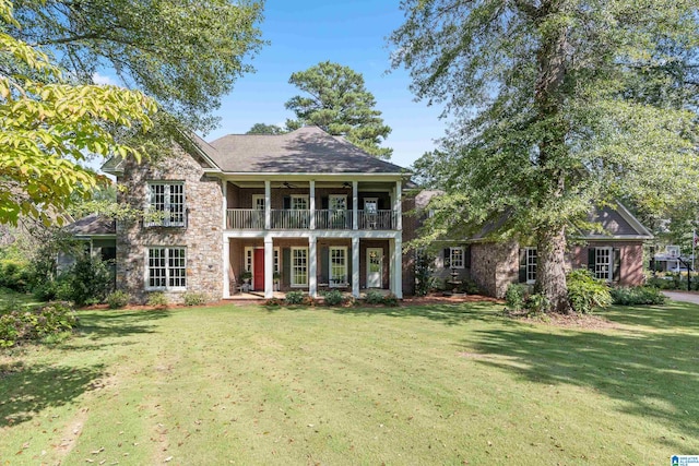 view of front facade with a balcony and a front yard